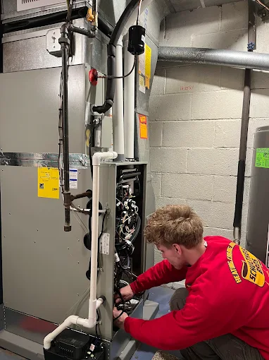 HVAC technician doing furnace maintenance in winter