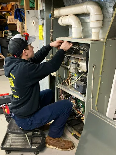 Schultheis Bros technician doing furnace repair and maintenance